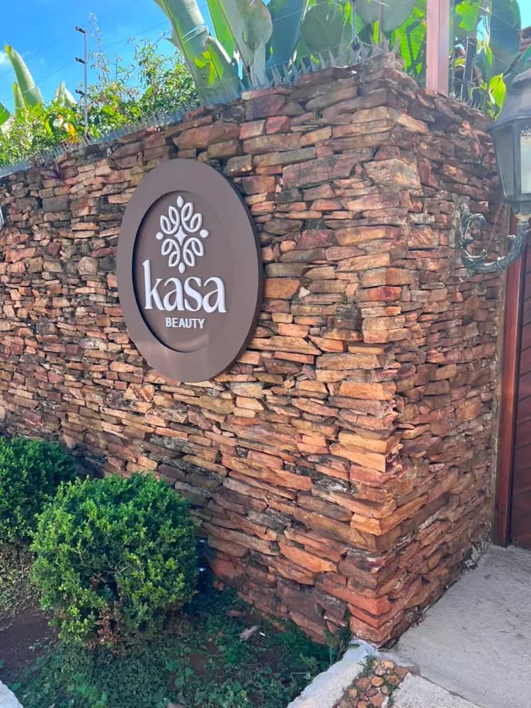 Entrada da Kasa Beauty, com a placa redonda na parede de pedra