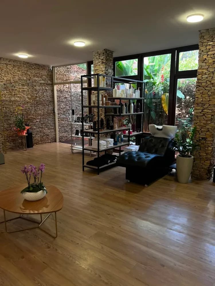 Prateleira de produtos e poltrona de atendimento da Kasa Beauty, com vista para o jardim