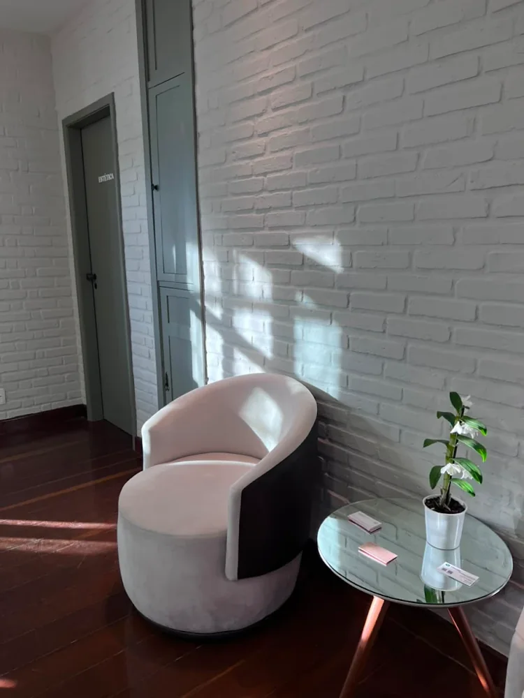 Sala de espera da Kasa Beauty, com poltrona estofada e orquídea